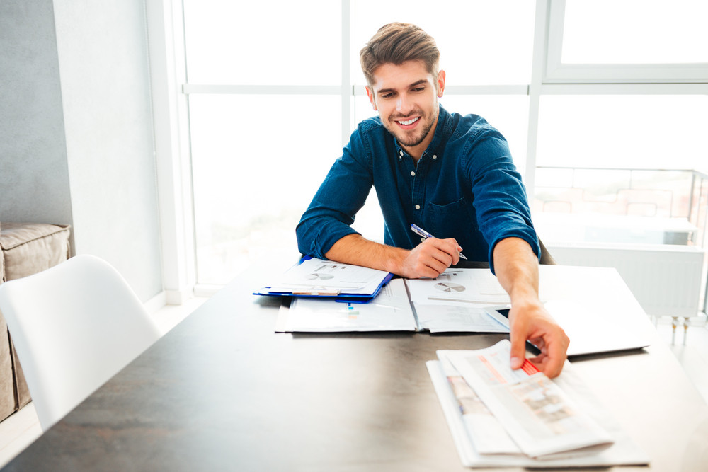graphicstock-photo-of-young-cheerful-bristle-man-analyzing-finances-and-holding-newspaper-in-hand_H_lc6FnBnx_PMNW.jpg